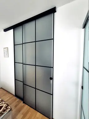 Klizne staklene stijene s crnim aluminijskim okvirom i mat staklom za moderan interijer